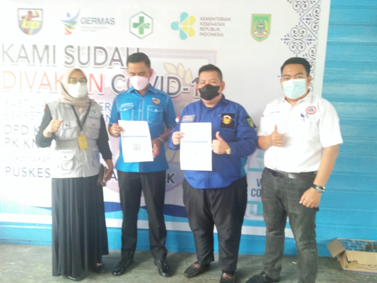 Ket.Photo : Ketua DPD KNPI Rohil Arie Sumarna, SE memegang Kartu Setifikat Vaksin Covid 19 Miliknya
